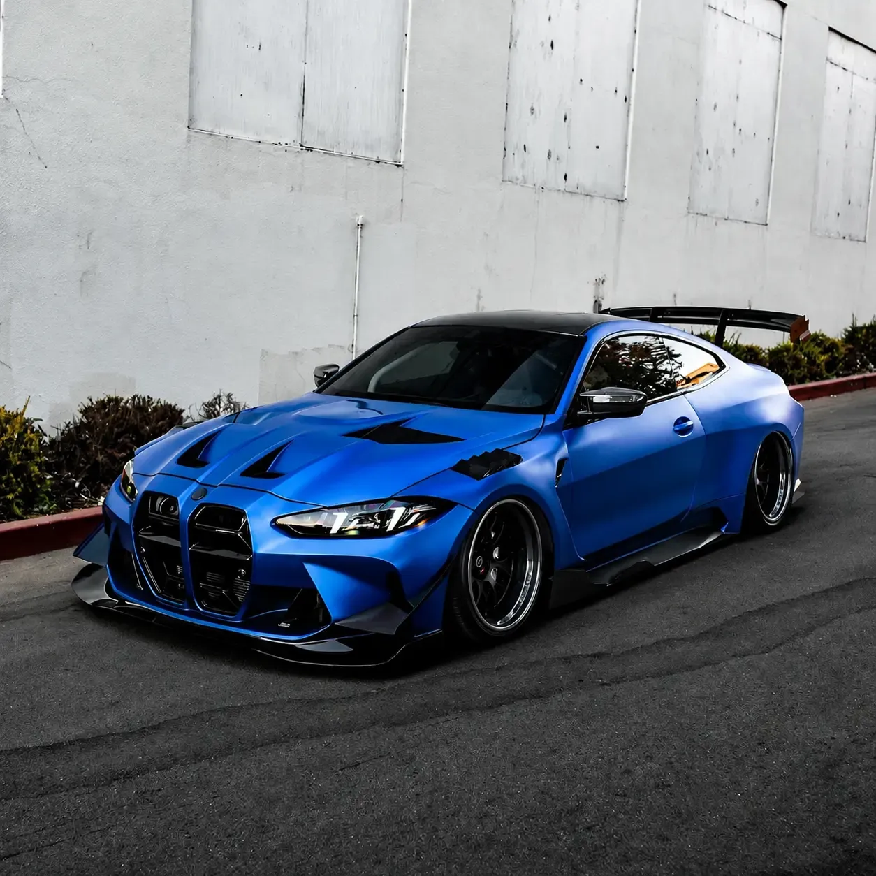 A two-door coupe in a satin blue color-change wrap, shot from the front quarter