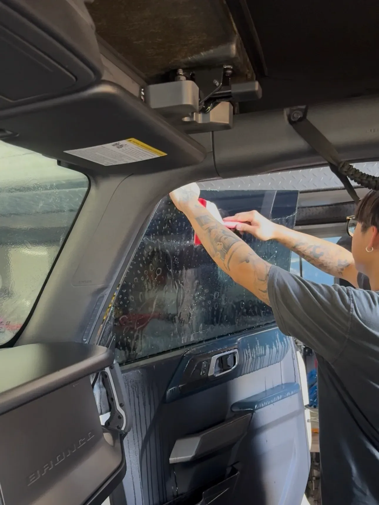 Tint being shaped into rear quarter glass