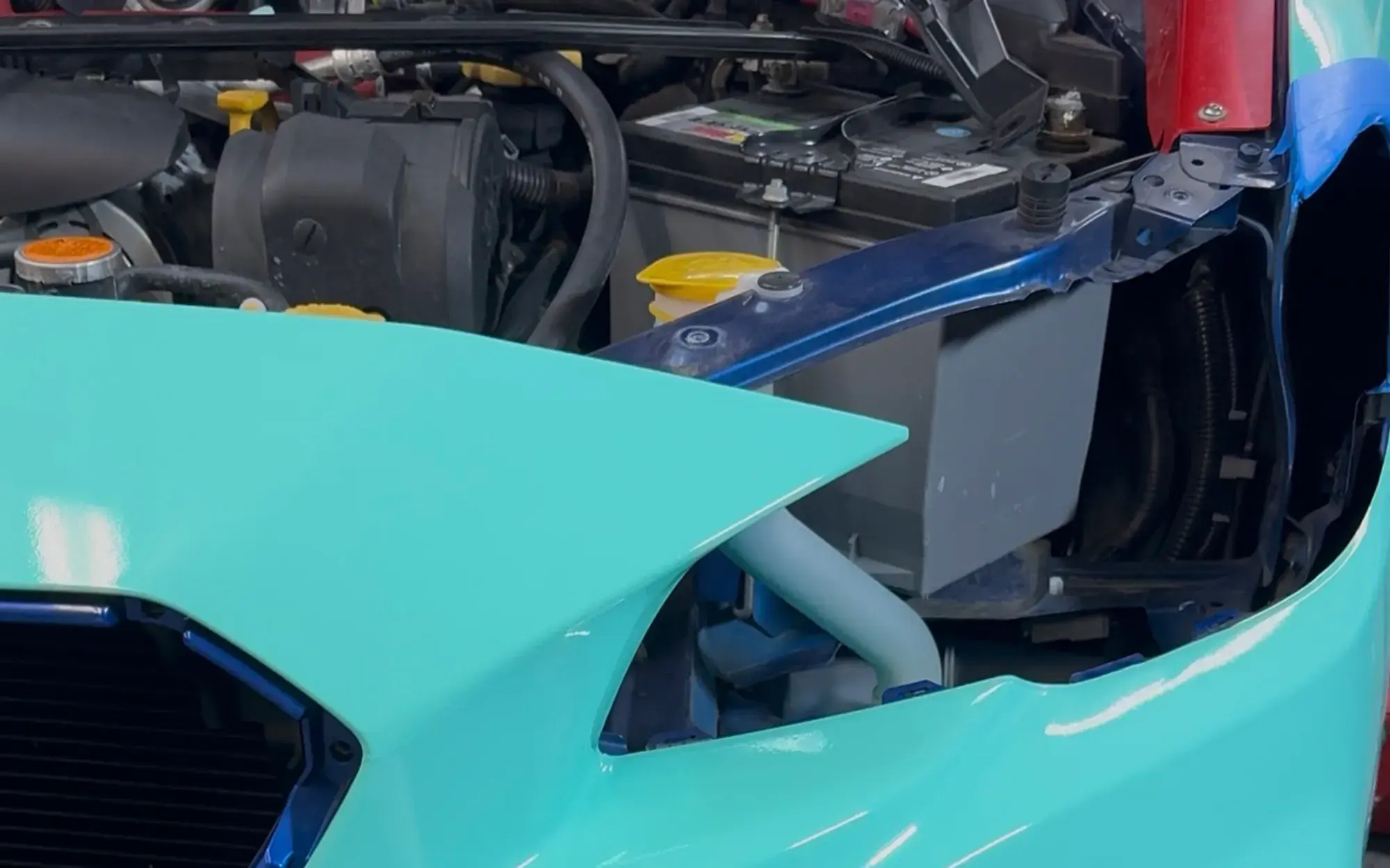Color-change vinyl being fitted around the intake of a front bumper